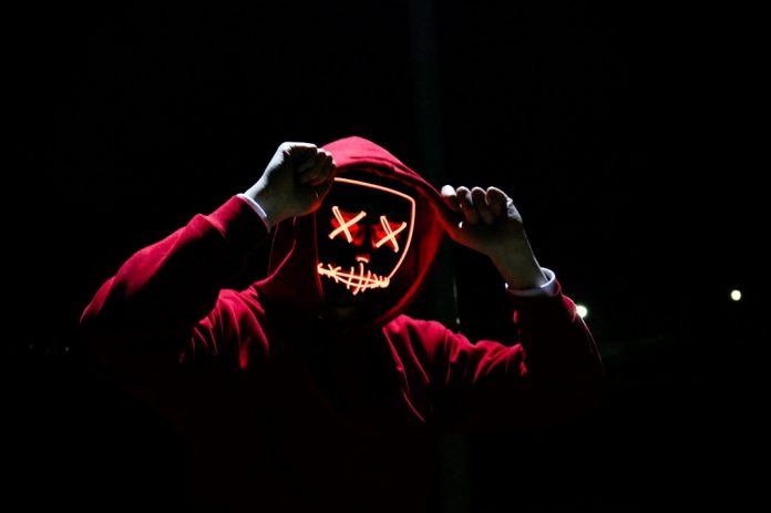 red hoodie person on black silhouette with digital face