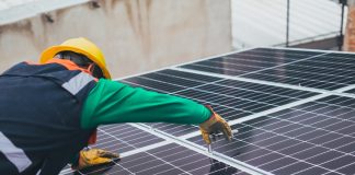 sustainability man fitting solar panel