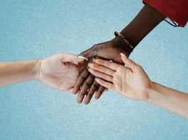 Intertwined hands of people of different color and race