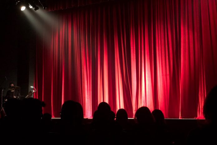 spotlight on empty stage with red curtain