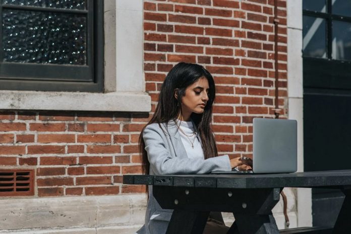 woman working remotely at laptop in city