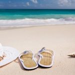 hat and shoes on sunny beach