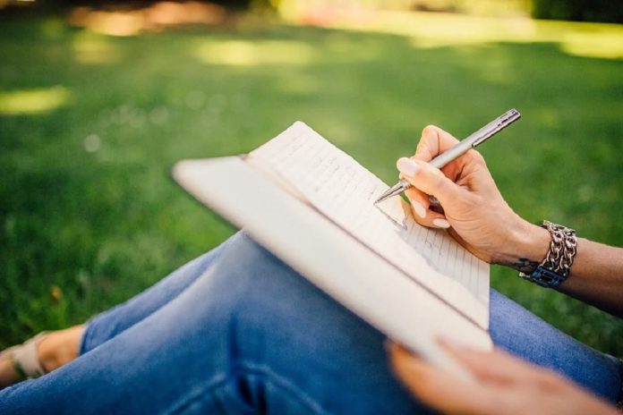 woman sittting in garden writing notes