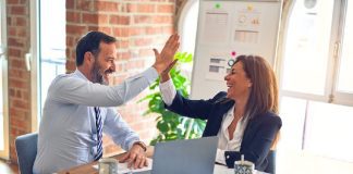 man and woman high fiving in office