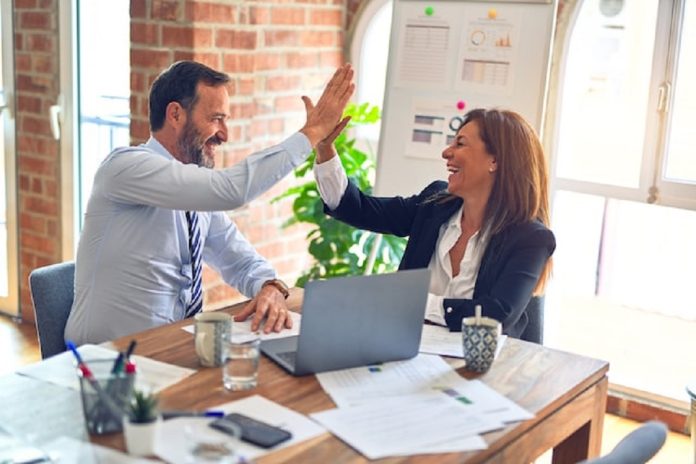 man and woman high fiving in office