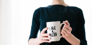 lady in black clothes holding a mug that says "like a boss"