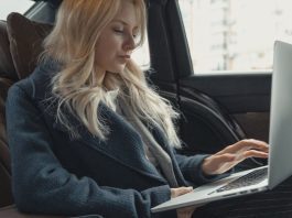 businesswoman in back of car on laptop