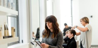 lady looking at tablet in hair dressoing salon