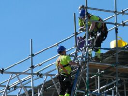 Construction worksite with workers on ladders